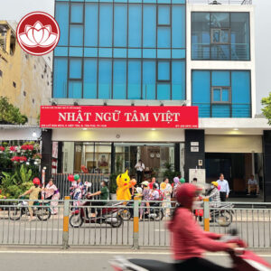 People in costumes and Pikachu mascot outside a Vietnamese language school on a busy street