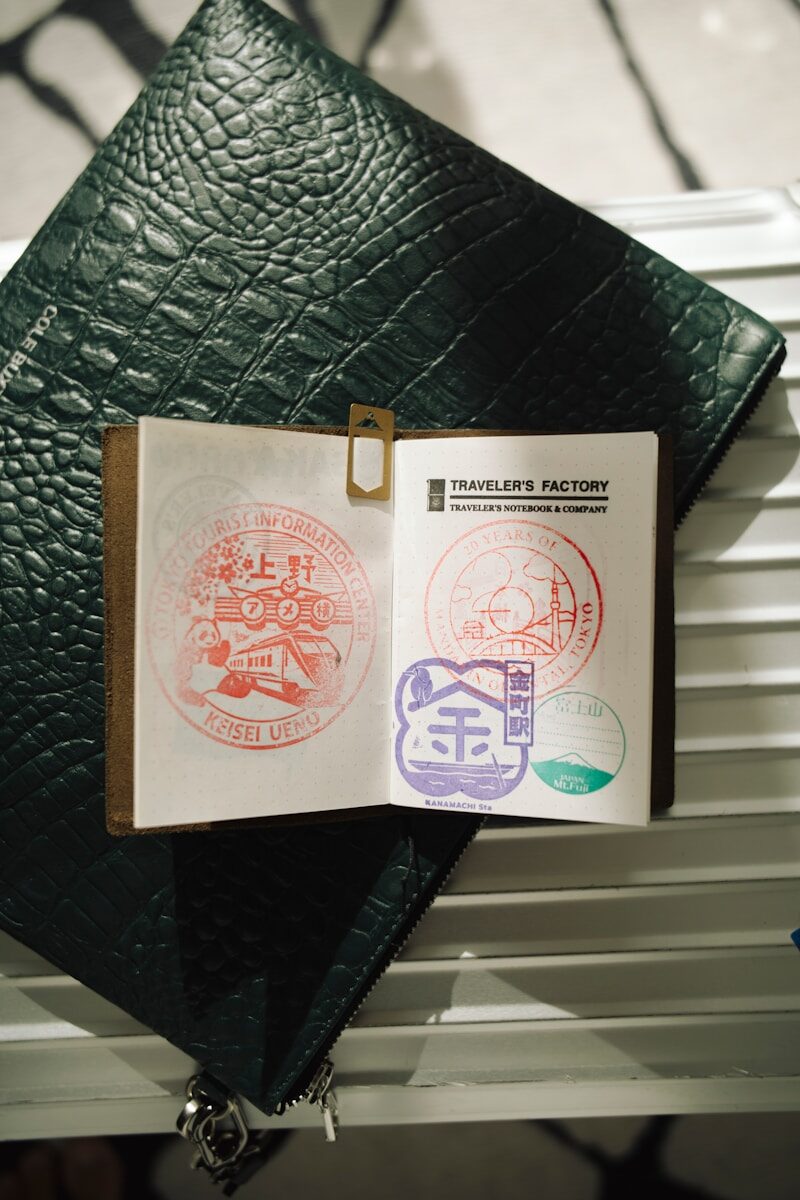 Open passport with colorful stamps and travel accessories.