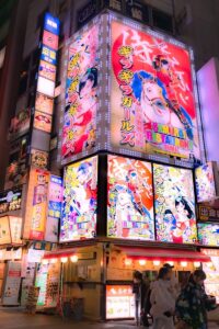 Nighttime in japan with bright, colorful signs.