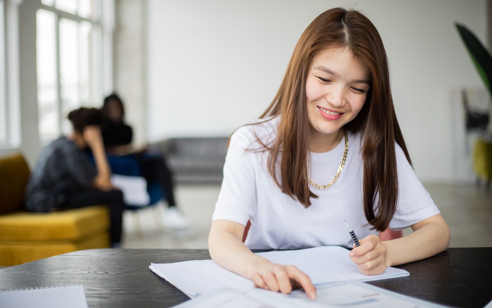 Cách học Kanji trong câu: phương pháp 1–3–3 để đọc nhanh hơn 2 Học viên châu Á học Kanji với sách và vở trong lớp