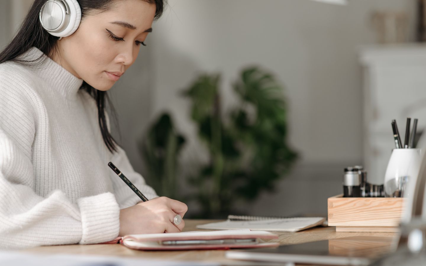 Cách shadowing tiếng Nhật 15 phút: quy trình theo tầng cho người mới 3 Người học châu Á đeo tai nghe và ghi chú khi đối chiếu kịch bản lời thoại tiếng Nhật.
