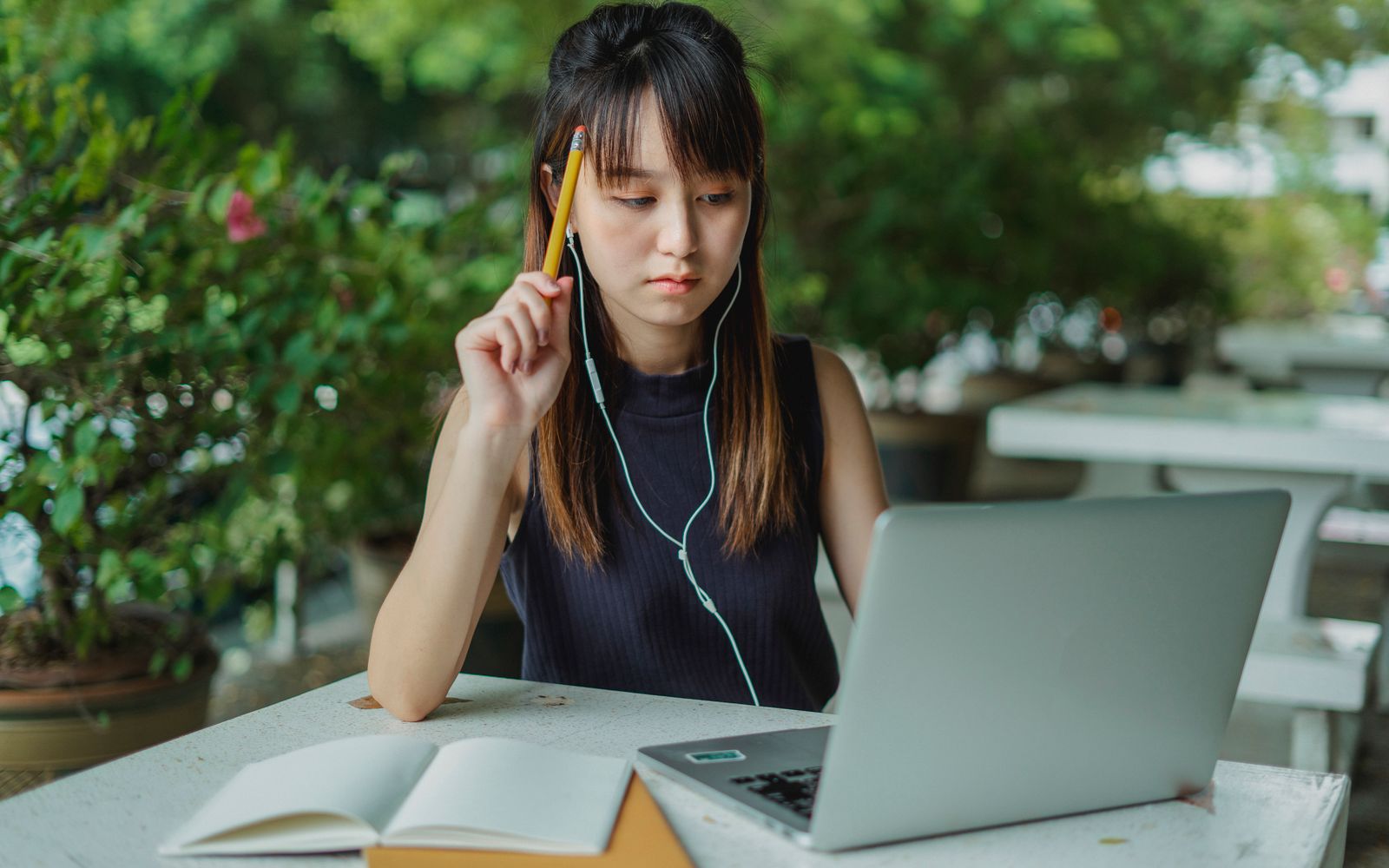 Cách shadowing tiếng Nhật 15 phút: quy trình theo tầng cho người mới 1 Người học châu Á đeo tai nghe, dùng máy tính và ghi chép khi luyện shadowing tiếng Nhật.