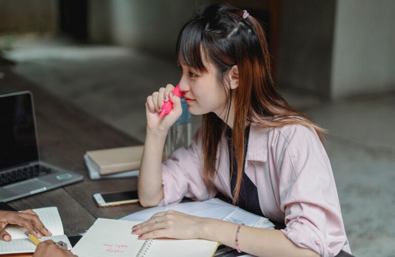 Người học châu Á ghi chép bên máy tính khi bắt đầu học tiếng Nhật